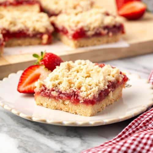 A single strawberry crumble bar served on a small dessert plate.