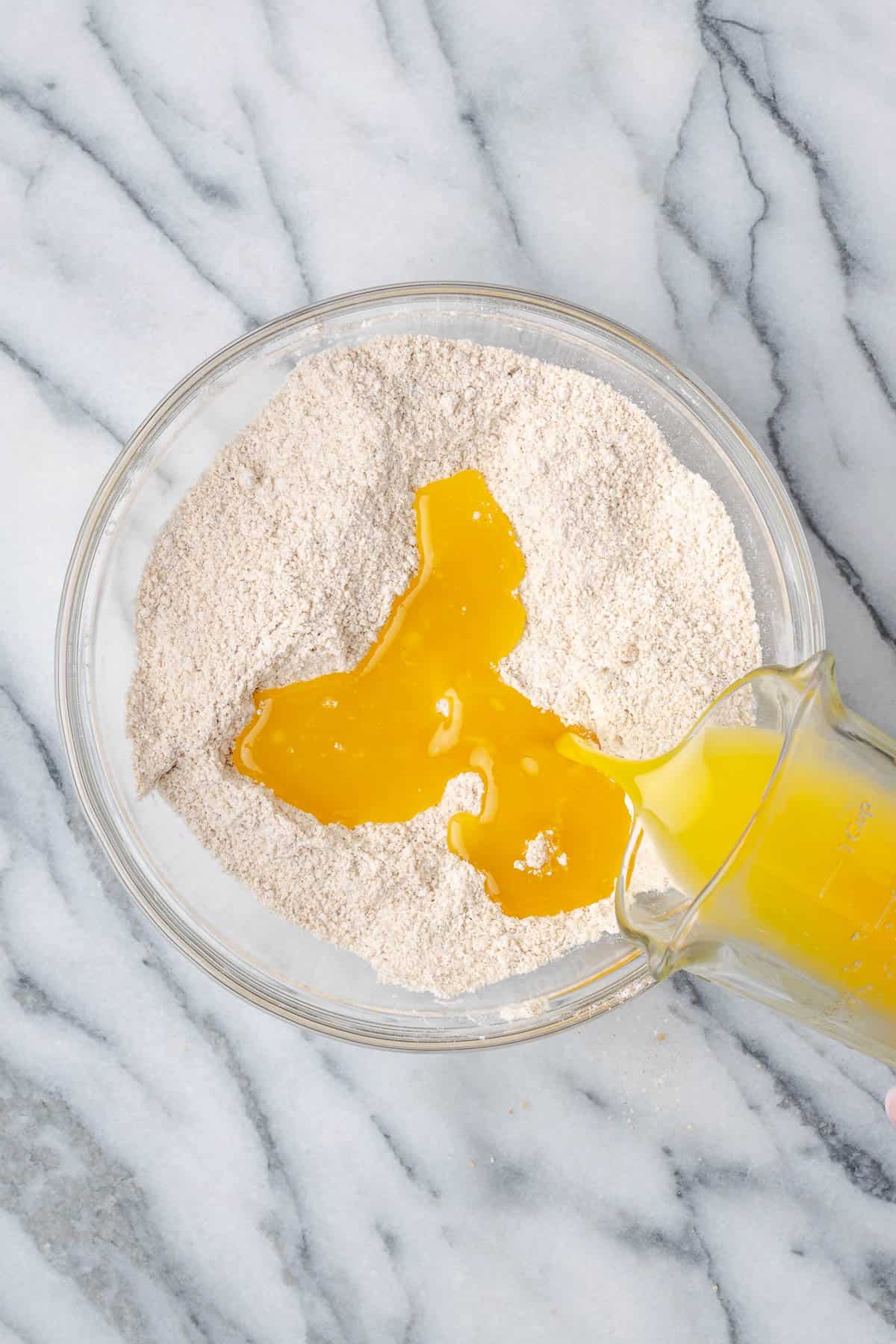 Melted butter being poured into the dry ingredients.
