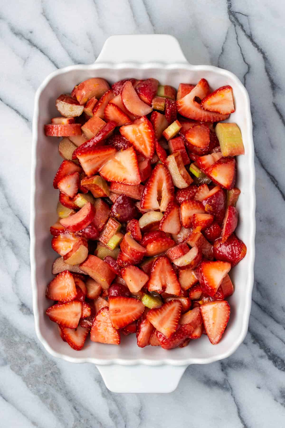 Strawberry rhubarb filling in a ceramic baking dish.
