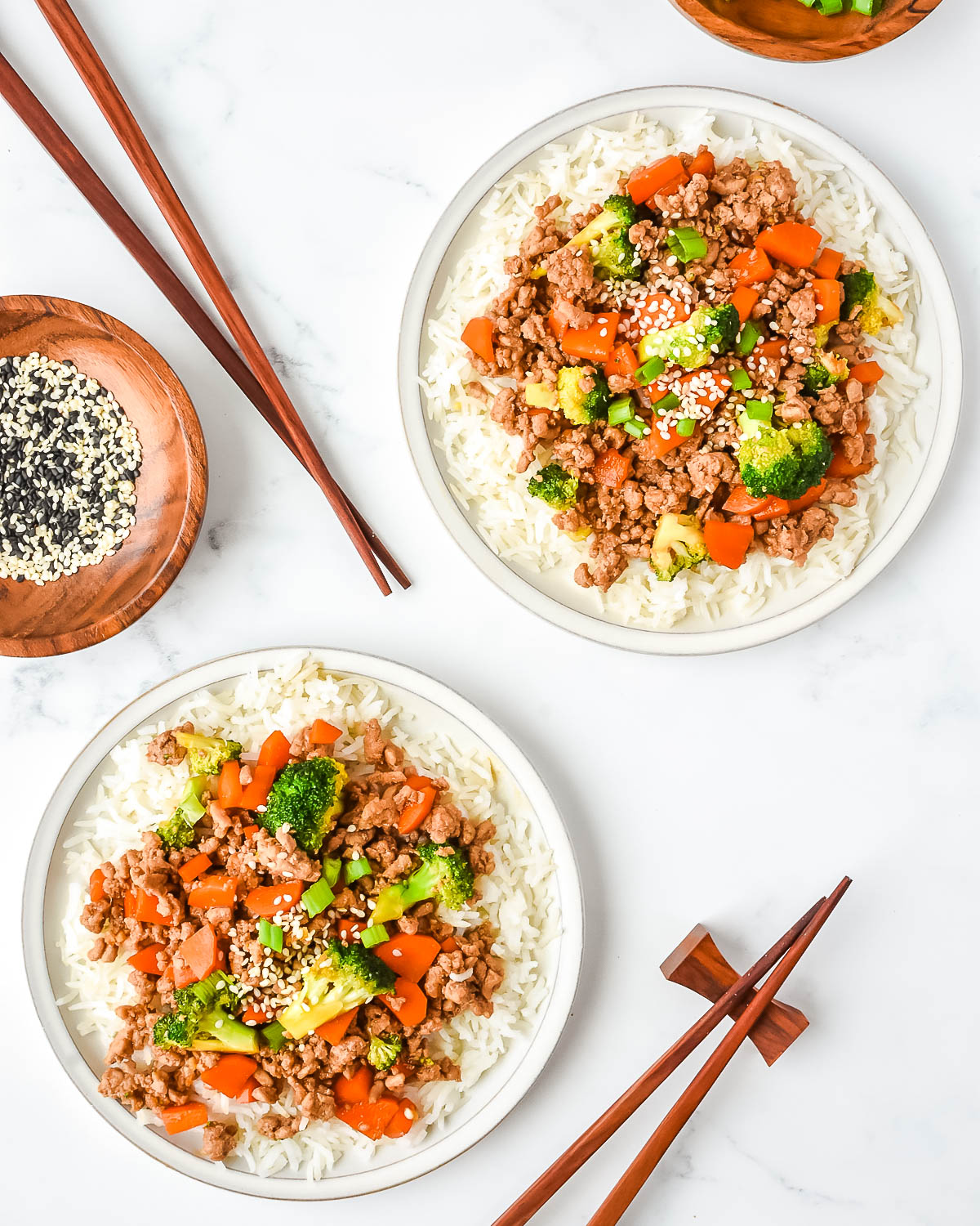 Two plates of ground turkey teriyaki served over white rice.