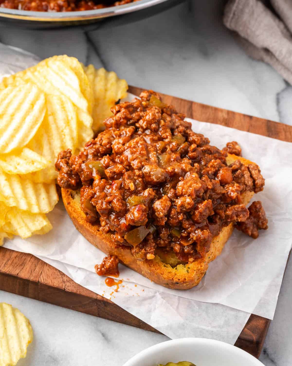 An open faced sloppy joe served on a piece of garlic bread Texas toast.