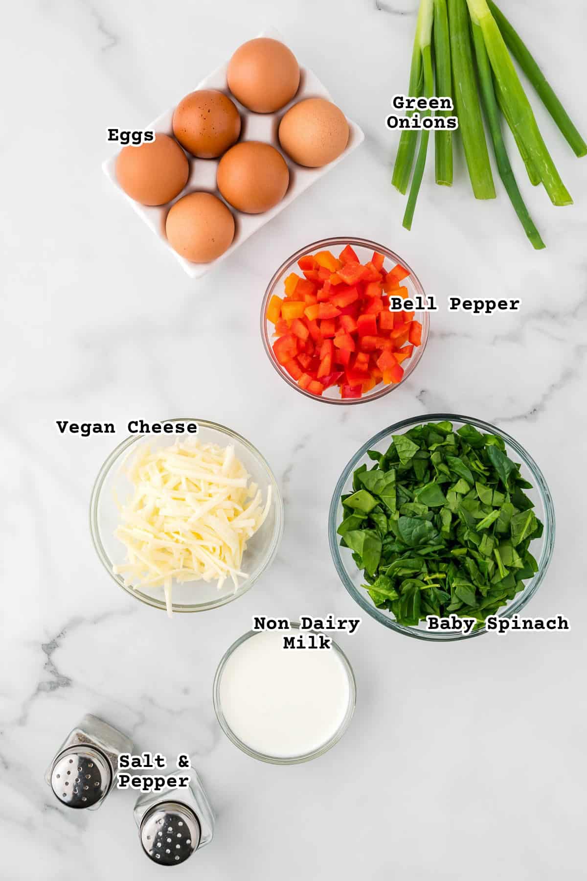 Ingredients for mini egg bites on a marble counter. 