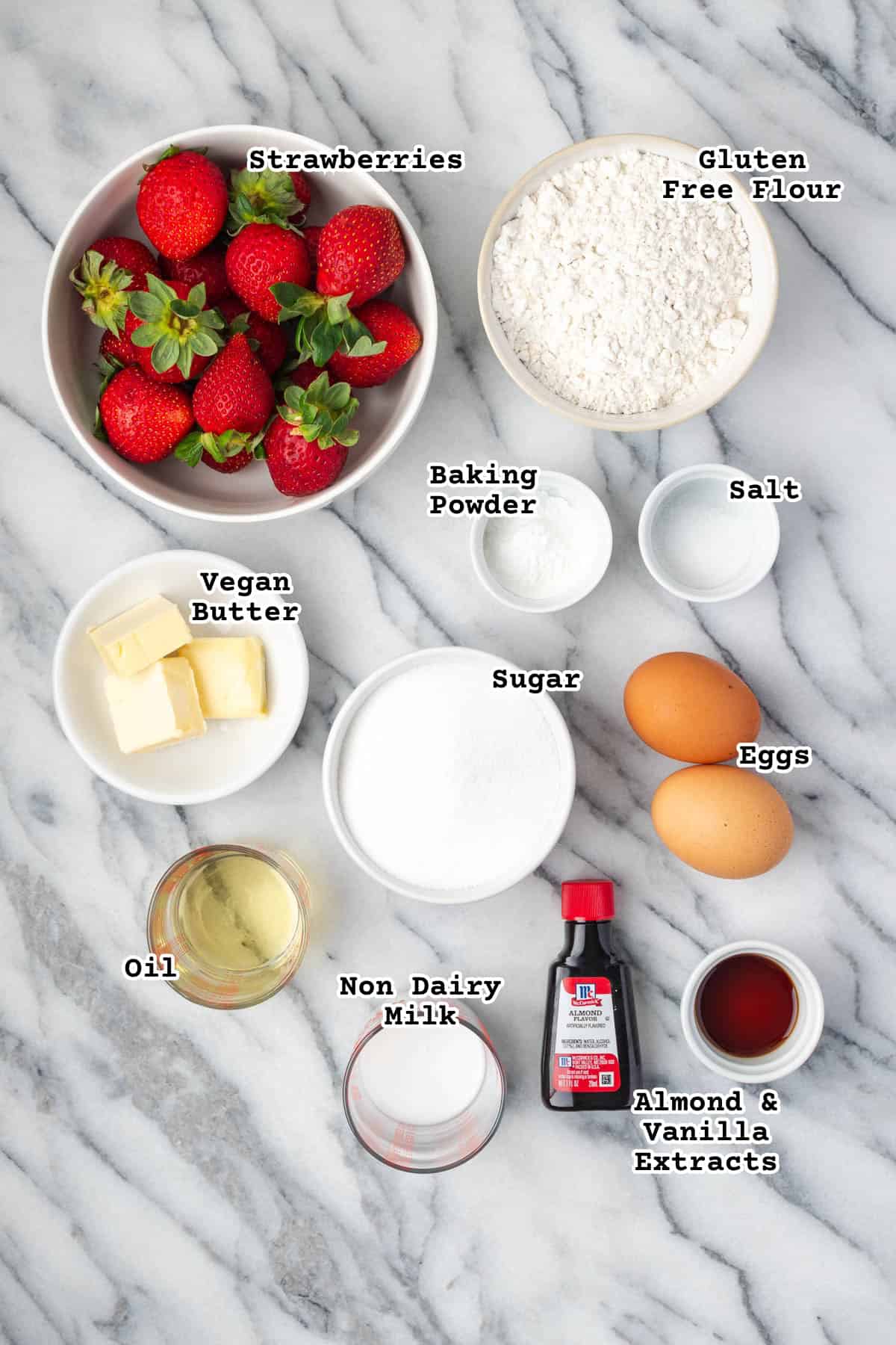 Ingredients for gluten free strawberry cupcakes sitting on a marble counter.
