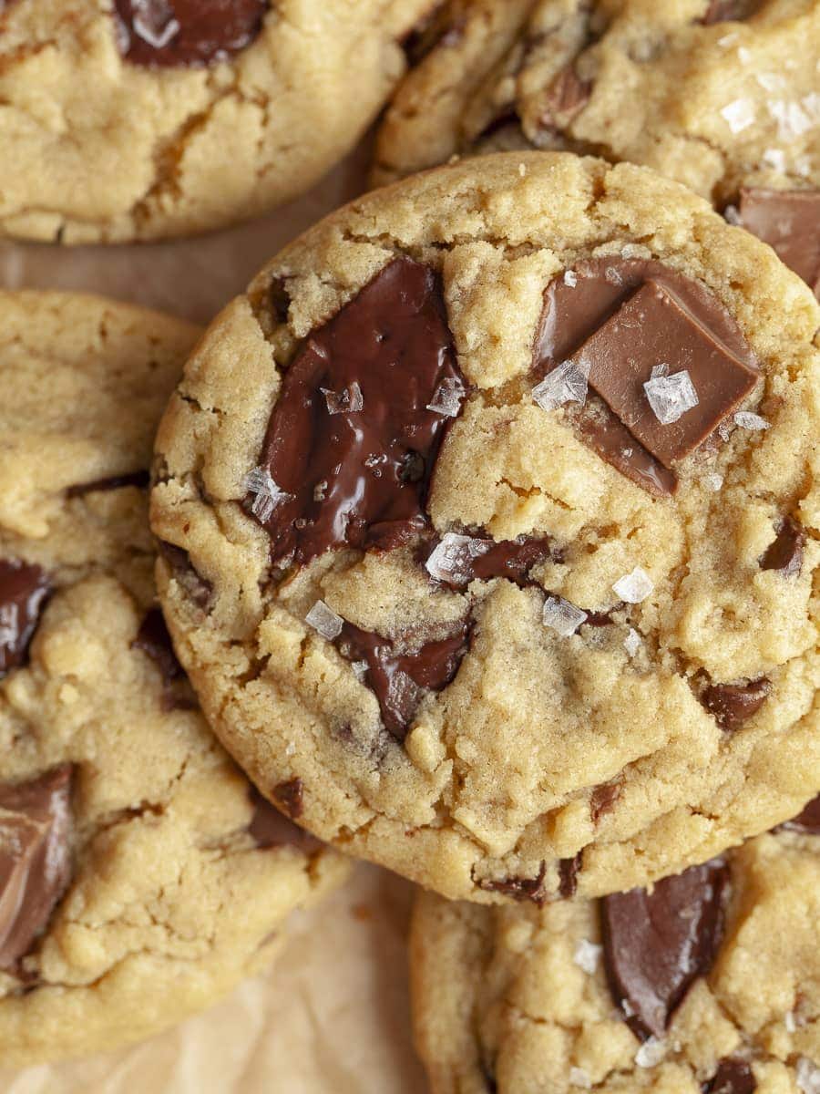 Peanut butter chocolate chip cookies stacked on a baking sheet.