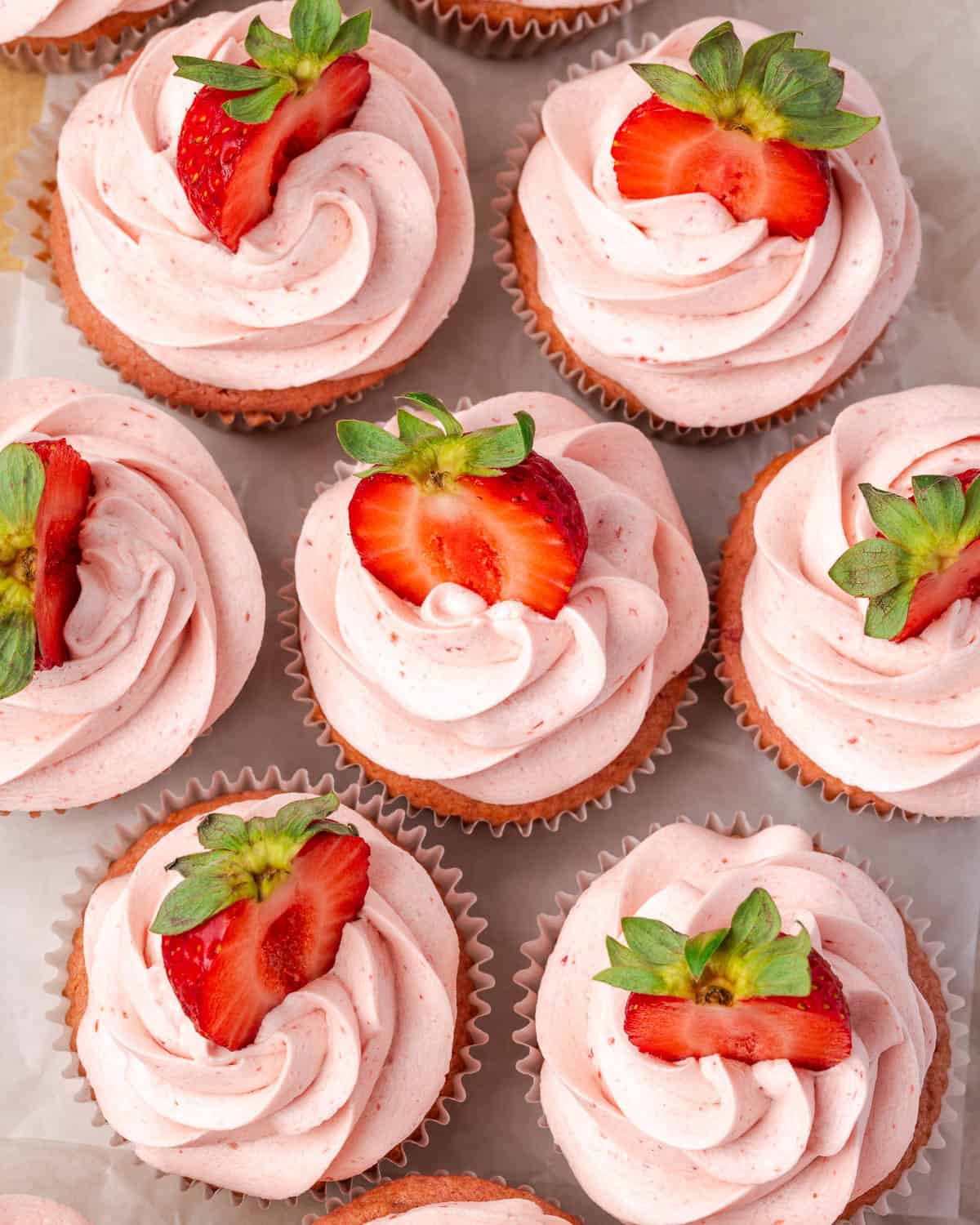 Several gluten free strawberry cupcakes sitting on a table.