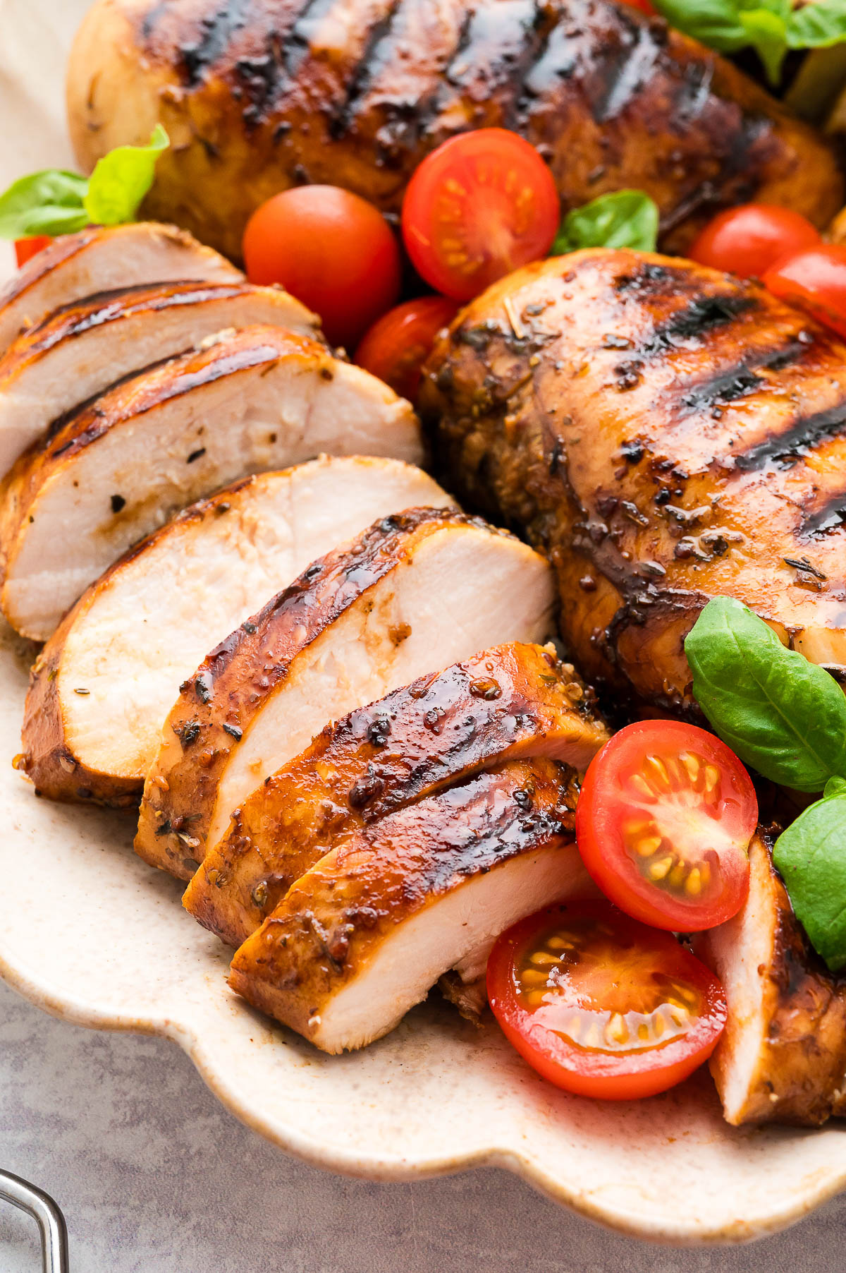 Several grilled chicken breasts with balsamic marinade on a serving platter.