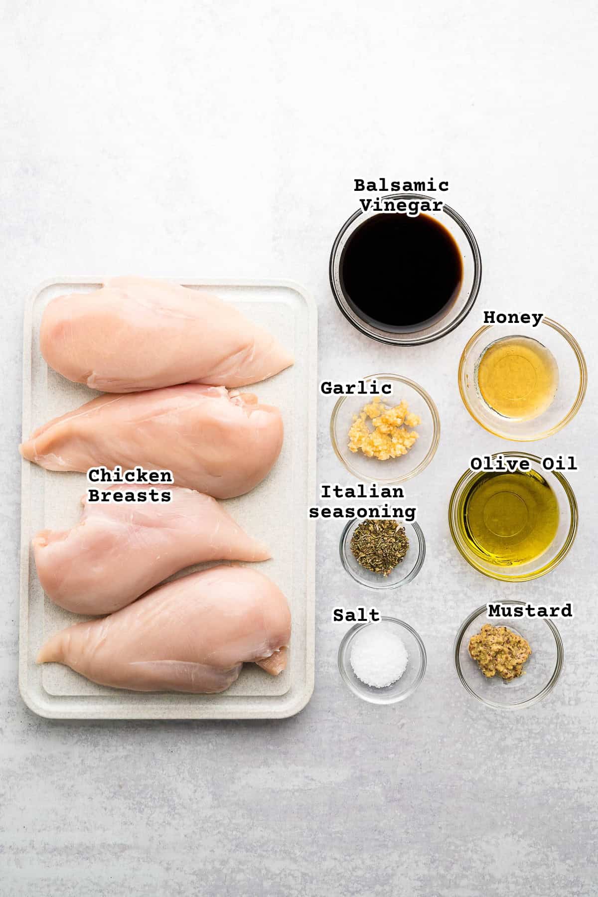 Ingredients for balsamic chicken on a concrete counter.