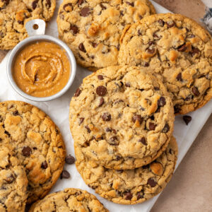 Several peanut butter oatmeal chocolate chip cookies scattered on a marble tray.