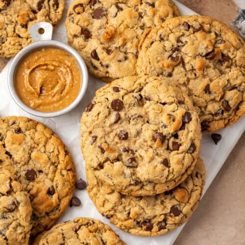 Several peanut butter oatmeal chocolate chip cookies scattered on a marble tray.